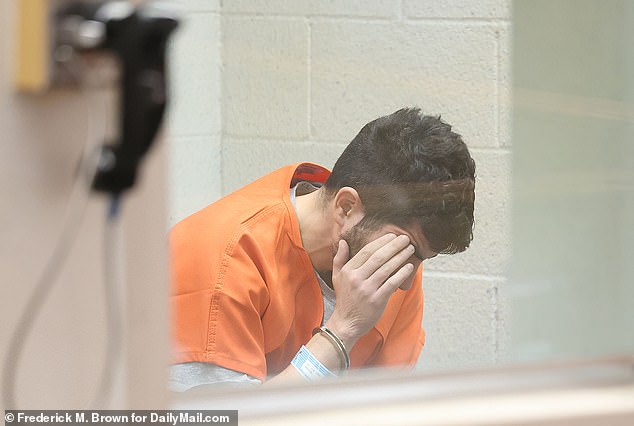 Rostomyan appears stressed, dressed in an orange prison jumpsuit, as he covers his face and lowers his head in exclusive pictures obtained by DailyMail.com