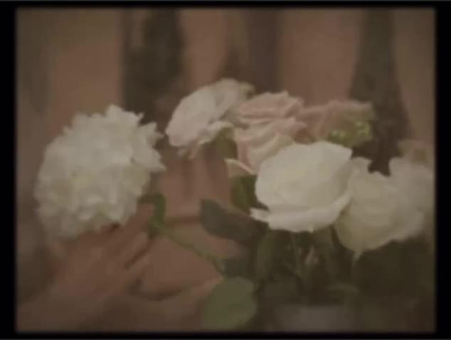 The video starts with a washed out video of a woman arranging white and pink pastel flowers