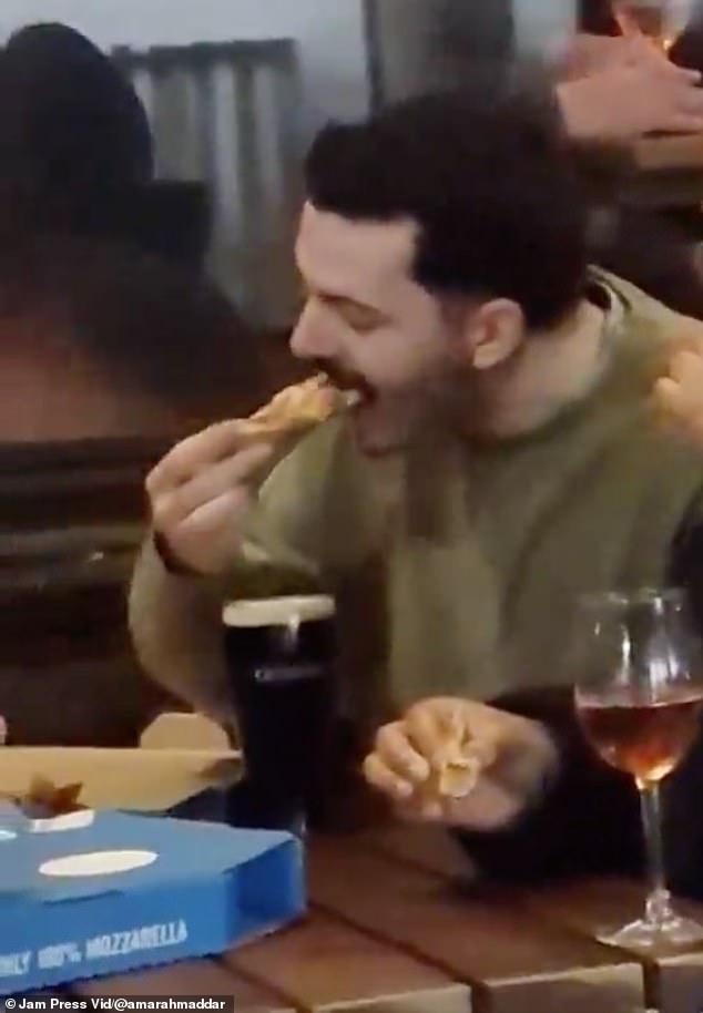 The reveler appeared to be enjoying a casual chat with his pals before submerging a whole slice of Domino's pizza into his Guinness and munching on it as if nothing had happened