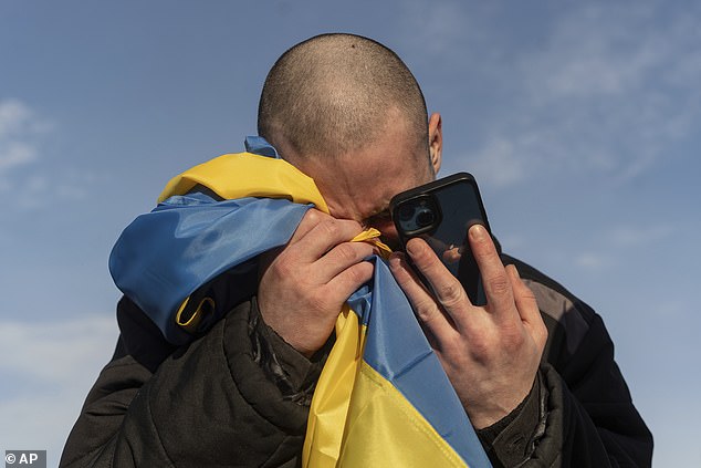 FILE - A recently exchanged Ukrainian prisoner of war cries as he calls his family after a prisoner exchange at the Ukraine-Russia border, Wednesday, Jan. 31, 2024.