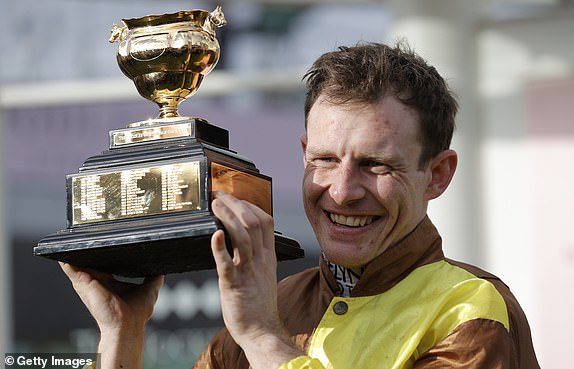 Jockey Paul Townend holds the trophy after victory over Galopin Des Champs in the Gold Cup during racing on day four of the Cheltenham National Hunt jump racing festival at Cheltenham Racecourse on March 17, 2023 in Gloucestershire, England (Photo by Tom Jenkins/Getty Images)