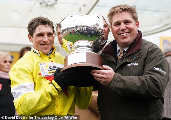 Harry Skelton and Dan Skelton lift the trophy after winning the Ryanair Steeple Chase with Protektorat on day three of the 2024 Cheltenham Festival at Cheltenham Racecourse. Photo date: Thursday March 14, 2024. PA Photo. See PA RACING story Cheltenham. Photo credit should read: David Davies for The Jockey Club/PA Wire.RESTRICTIONS: Editorial use only, commercial use is subject to prior permission from The Jockey Club/Cheltenham Racecourse.