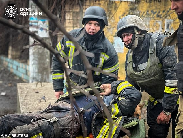 Rescuers carry a wounded colleague at the scene of the Russian missile attack