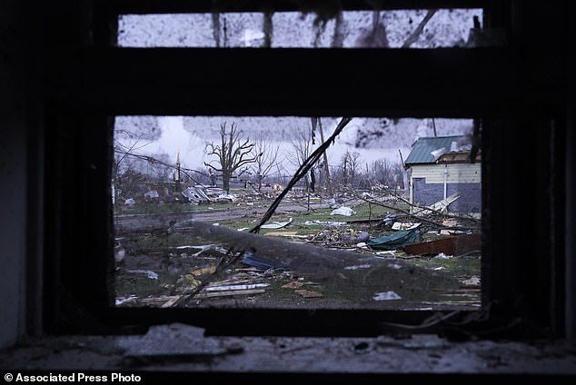 Debris is visible through the window of a damaged home after the severe storms in Lakeview, Ohio