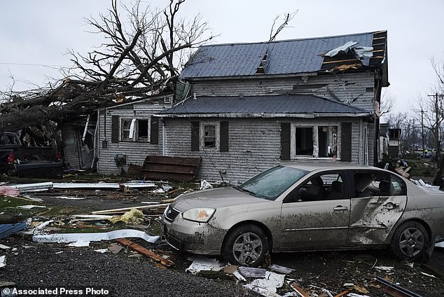 Debris is visible near a damaged home after the extreme weather that tore through the Midwest Thursday night and Friday morning