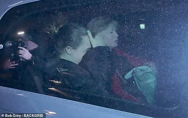 Holding her hand to her head, the British star cut a relaxed figure in a black coat as she sat in the back of a car with several bags and her mum