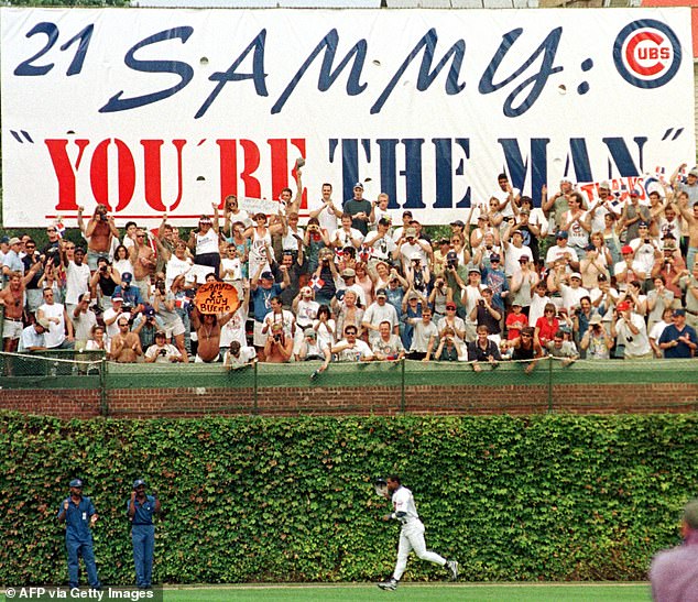 Sosa runs under a banner hanging in the stands while taking a lap around Wrigley Field in 1998.