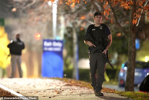 Law enforcement officers carry rifles outside Central Maine Medical Center during an active shooter situation in Lewiston, Maine, Wednesday, Oct. 25, 2023