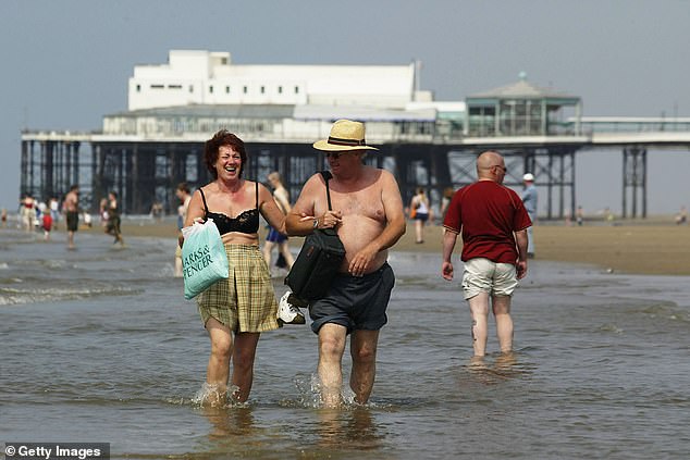 A couple go into the sea on Blackpool beach on August 6, 2003 as the temperature reached 35.9C
