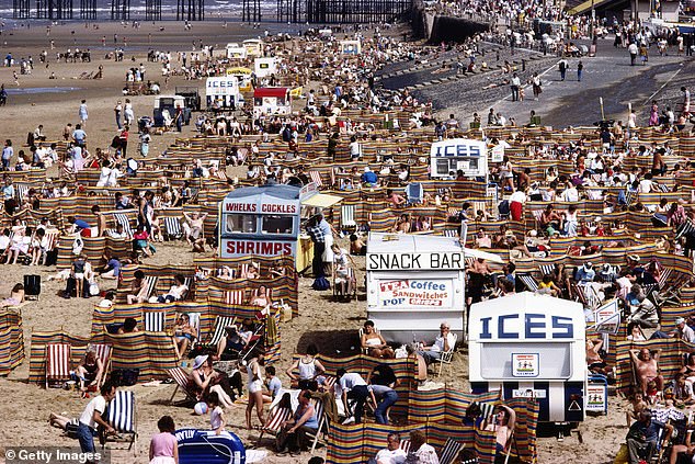 Crowds of holidaymakers and kiosks offering tea, coffee, ice cream, puppies and cockles and prawns on Blackpool beach in August 1983