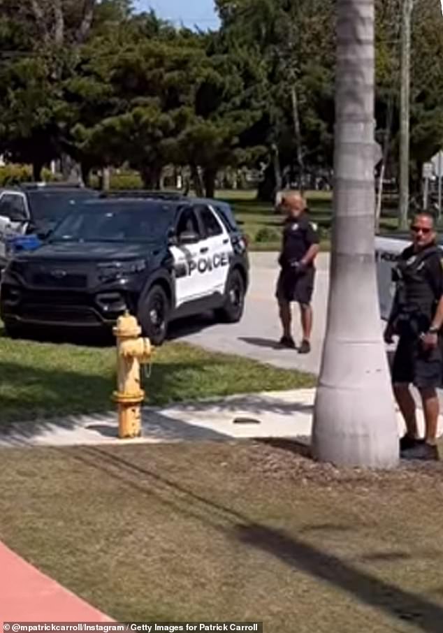 Miami police officers are seen at the scene outside Carroll's house