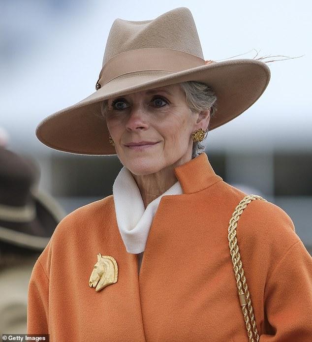 All about the accessories: A woman picked a gold horse brooch to complete her elegant ensemble