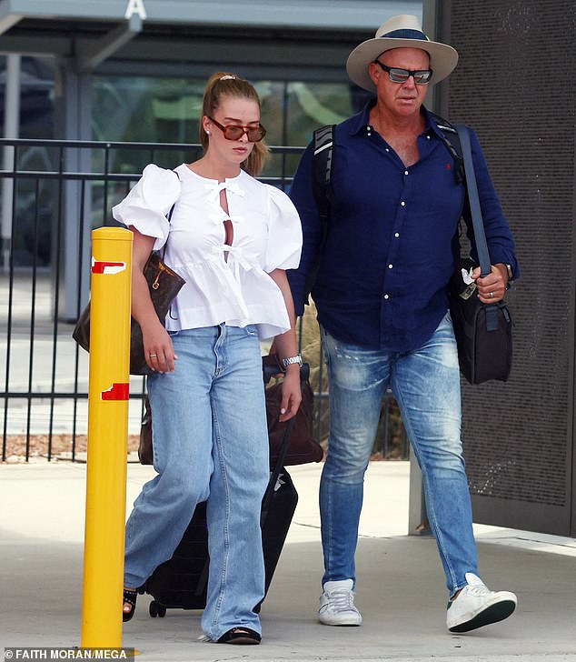 Wearing loose blue jeans and black sandals, she left the terminal with her father