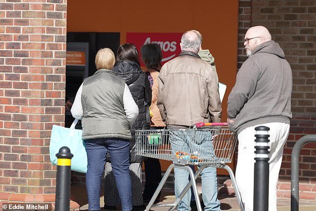 Shoppers queue for the cash machine outside Sainsbury's in Lyons Farm, Worthington