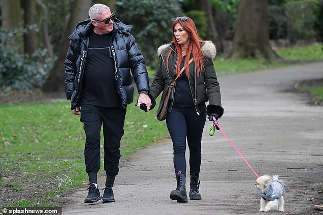 The Real Housewives Of Cheshire star wore a dark khaki green faux fur hooded coat and walked her adorable Pomeranian on a pink leash