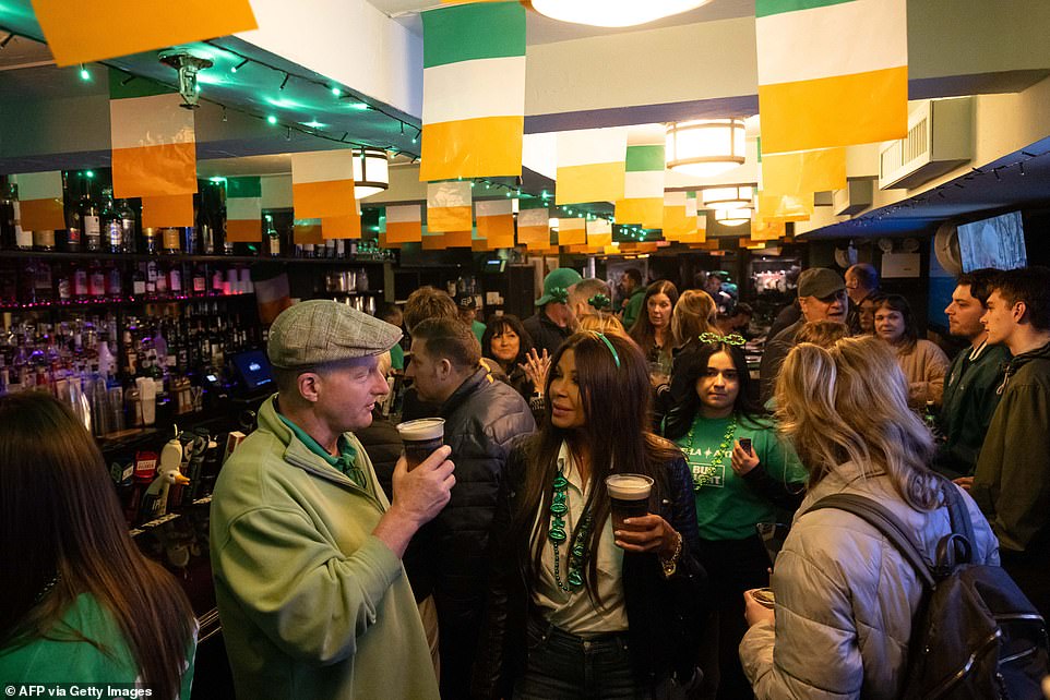 Bar guests celebrate under St. Patrick's Day Parade in New York City