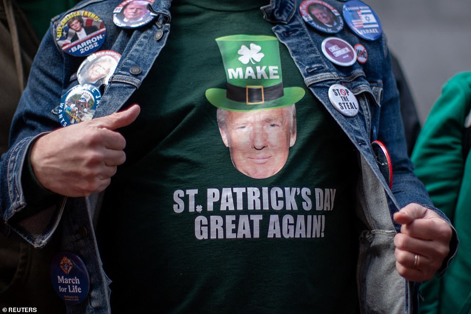 A man wears a t-shirt featuring Donald Trump's face as he takes part in the annual Saint Patrick's Day Parade