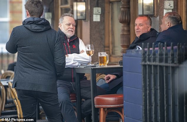 The former Big Brother housemate was seen chatting animatedly with his pals, who were sipping beers and puffing away on cigars