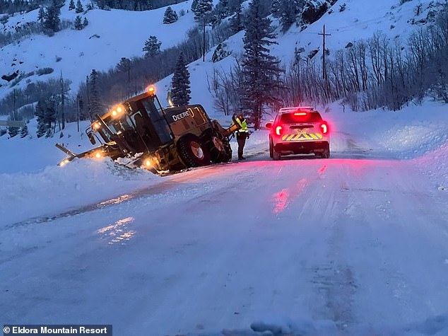 A six-wheel John Deere grader went off the road and got stuck in a snowdrift while trying to clear a path for traffic