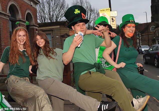 Five people get in the Irish mood with green outfits and tall hats