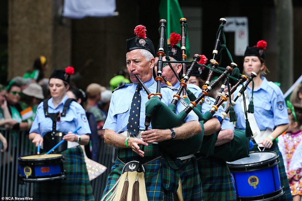 Man is seen playing the bagpipes while marking in the St Patrick's Day parade in Sydney's CBD