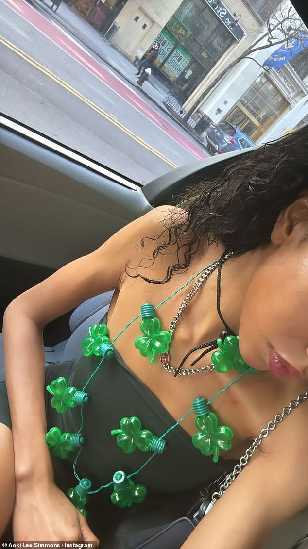 Aoki Lee Simmons, 21, shared a photo of herself wearing a string of green shamrock candles as a necklace over a black mini dress on her Instagram Stories