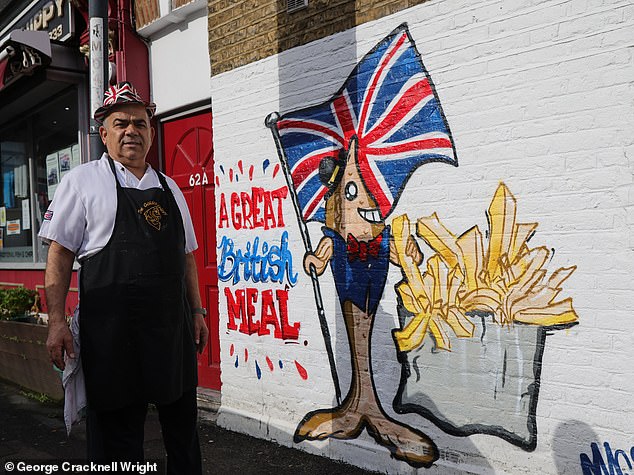 Pictured: Golden Chippy owner Chris Kanizi stands next to the Union Flag mural painted on the side of his restaurant