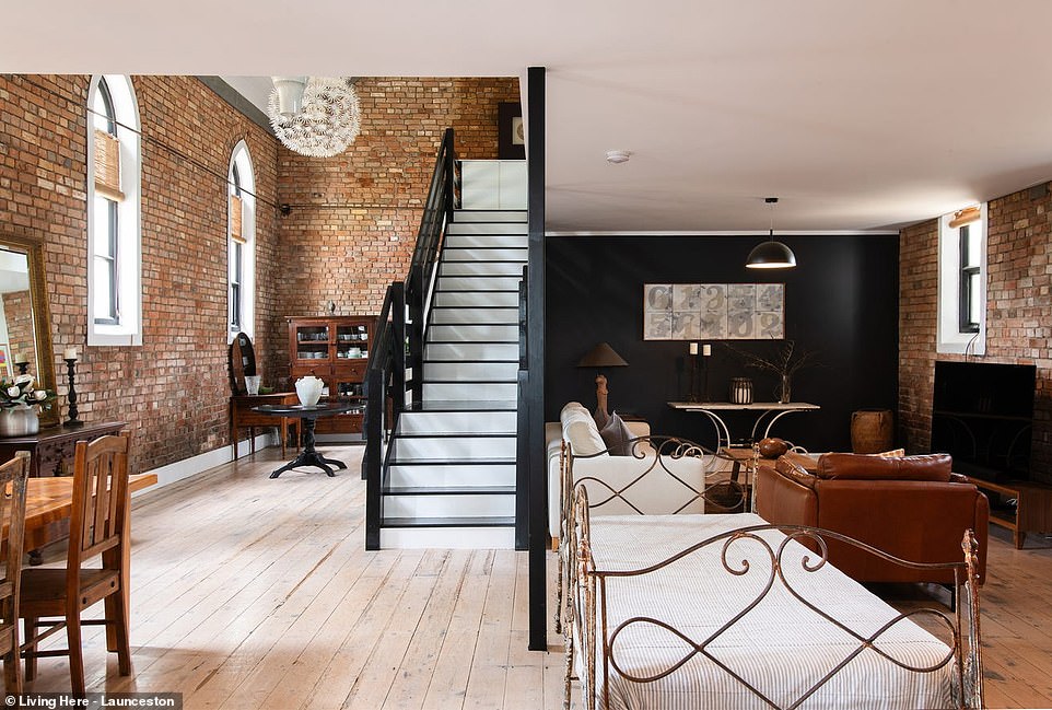 Inside, the trendy black and white color palette and modern luxury complement the original details, from exposed brick walls to Gothic arched windows.