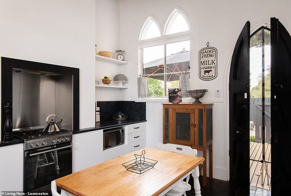 The simple but chic kitchen sits at the rear of the house and connects to an open-air gravel courtyard patio with a black wooden shed.