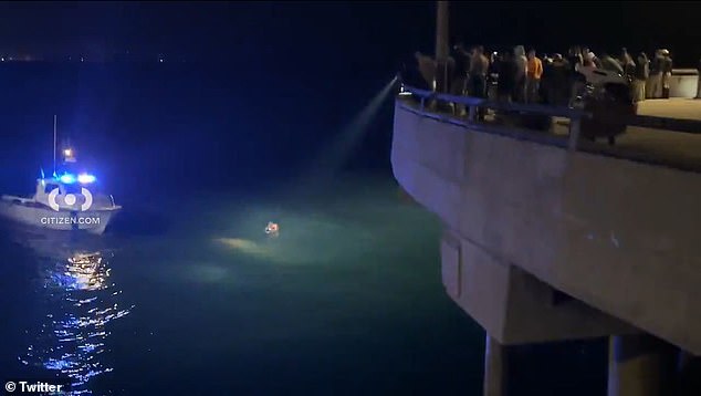 A spotlight is shined on the woman who was in the water after diving into the waves.