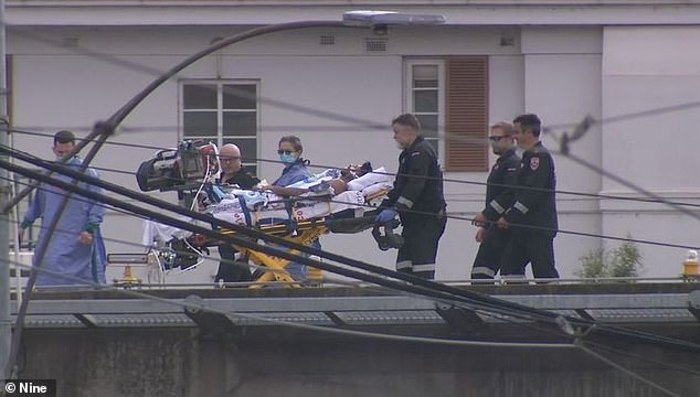 One of the men died while the other two remain in hospital (photo: one man lies on a stretcher far from the beach)