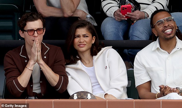 While sitting in the stands, Tom in a polo shirt looked handsome as he got closer to his girlfriend.