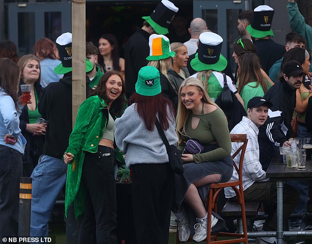 LEEDS: Revelers wearing leprechaun hats gather outside pub