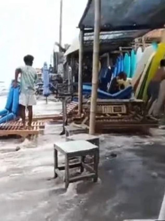 A video has been released showing the wild weather hitting Canggu Beach in Bali.  Footage shows a man desperately trying to save items washed away from beach stalls.