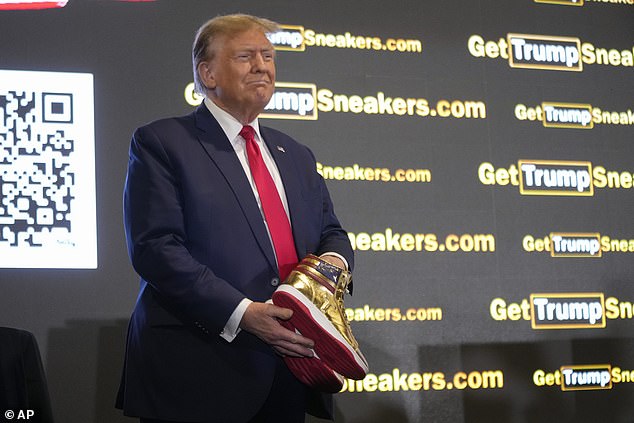 Republican presidential candidate, former President Donald Trump, holds gold Trump sneakers at Sneaker Con Philadelphia