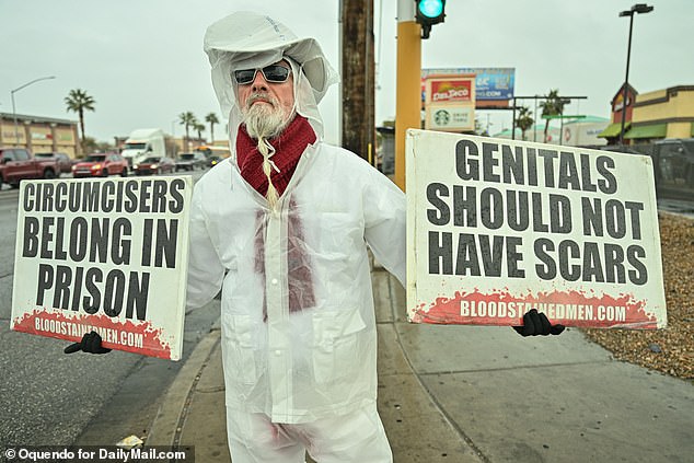 An anti-circumcision activist holds signs in Las Vegas, US, including one calling for the imprisonment of doctors who perform the procedure.