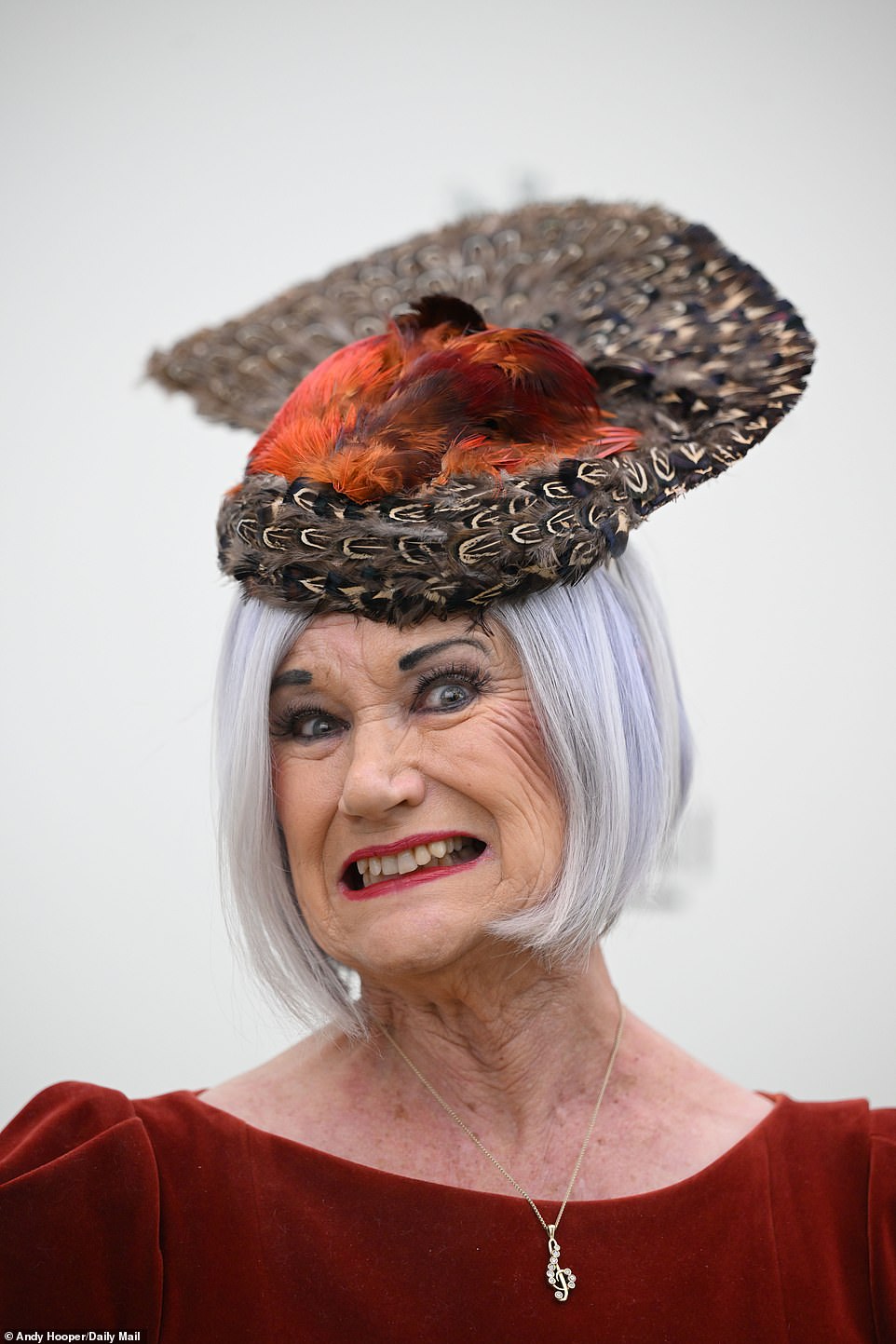 A lady shows off her extravagant hat, also known as a fascinator, with hats being a key part of the Cheltenham Festival dress code.