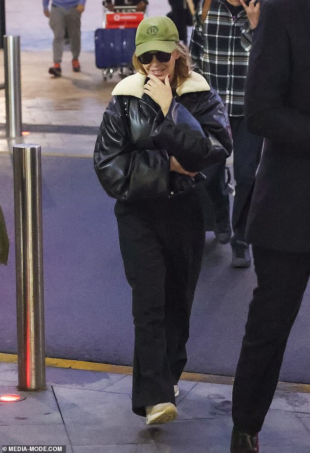 Kylie looked shy as she left Sydney Airport