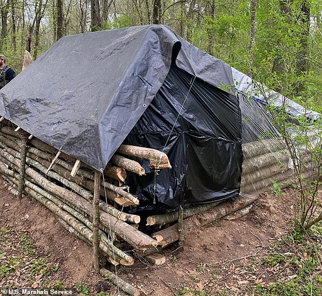 The shelter was made of branches stacked together and covered with trash bags and a tarp.