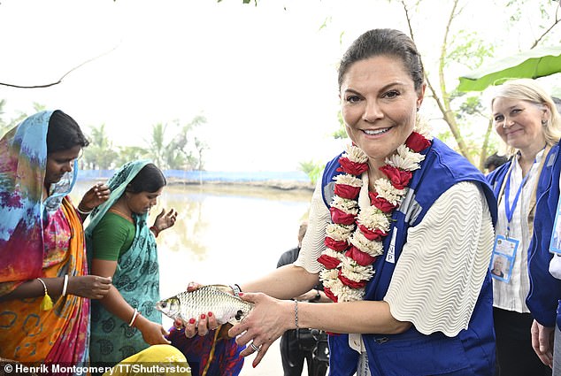 Elsewhere, the royal beamed for a moment as she held a fish in another photo during her visit to the women-led community project.