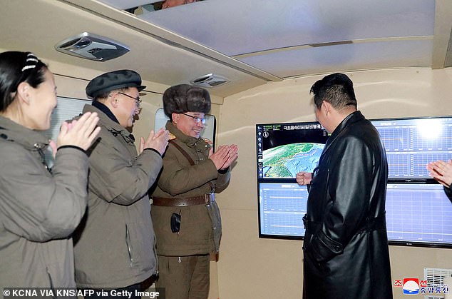 This photo released on January 12, 2022 shows Kim Jong Un (right) speaking with military officials.