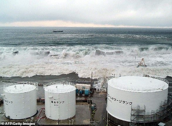 Tsunami waves crash over seawalls towards TEPCO's Fukushima Daiichi nuclear power plant in Okuma