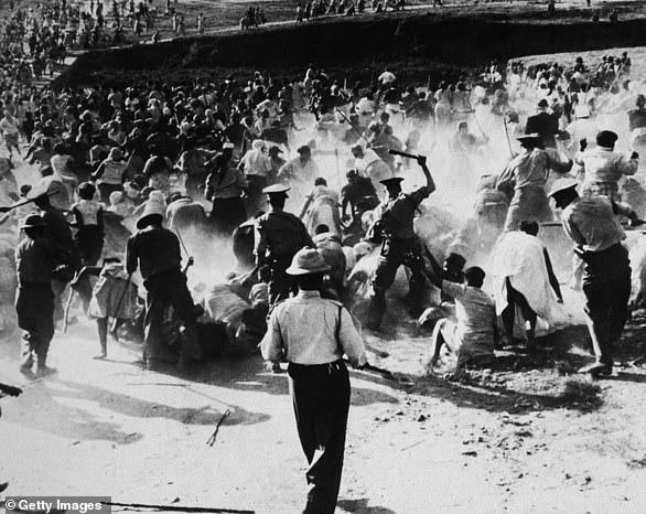 1959: South African police beat black women with batons after raiding and burning a brewery to protest apartheid, Durban, South Africa.