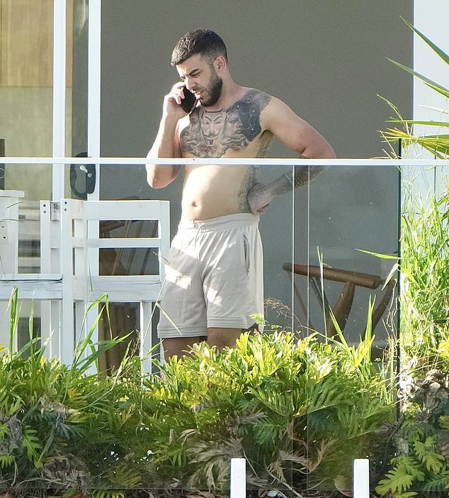 The millionaire real estate investor, 34, was spotted flaunting his tattooed torso on his hotel balcony while spending time with his family on Wednesday.