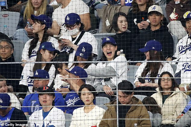 Mamiko Tanaka, wife of Shohei Ohtani, laughs with her friends in the crowd during Wednesday's match