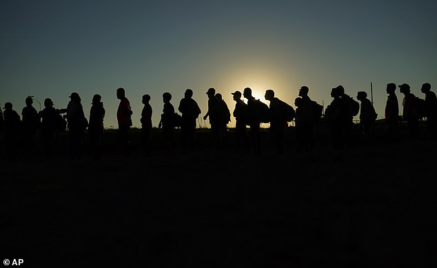 Migrants who crossed the Rio Grande and entered the United States from Mexico wait in line to be processed by U.S. Customs and Border Protection, September 23, 2023, in Eagle Pass, Texas.