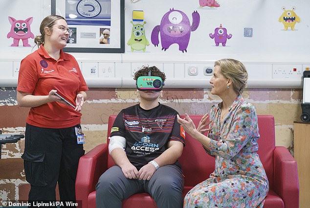 Sophie (pictured, right) meets patient Brayden McGibbon, 13 (pictured, center) and VR gaming specialist Lucy Dove (pictured, left) demonstrating Virtual Reality Distraction Therapy (VRDT)