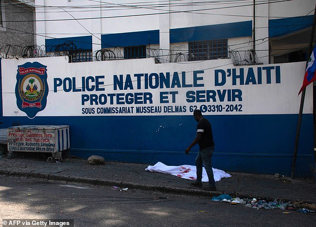 Residents of communities under fire have called radio stations to plead for help from the Haitian National Police, who are outnumbered by the gangs. A body lies in front of the police building in Port-au-Prince