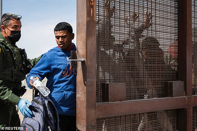 A U.S. Border Patrol agent searches a group of migrants let through by the Texas National Guard in El Paso, Texas, on Wednesday.