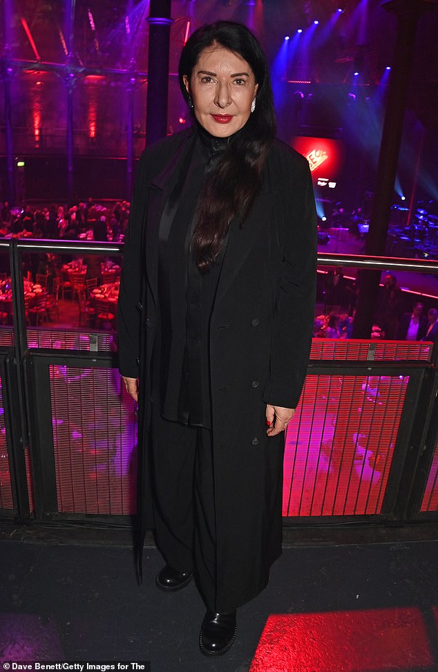 Renowned performance artist Marina Abramovic looked elegant in a black satin shirt and fitted coat, while adding a pop of color with a classic red lip.